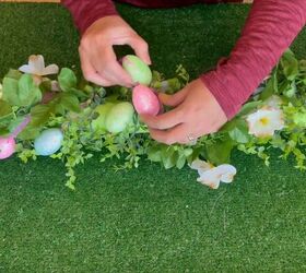 Adding a festive touch with a string of eggs wrapped around the garland base
