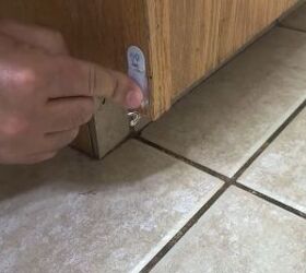 He sticks Command hooks under his kitchen cabinet for a clever trick