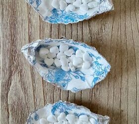 concha de ostra, Tres conchas de ostra decorativas cada una llena de peque os caramelos blancos dispuestas sobre una superficie de madera