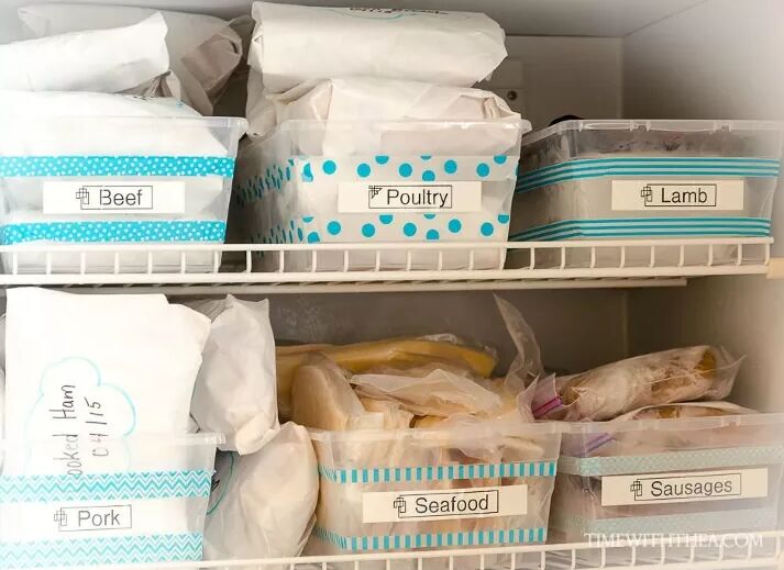 Blue washi tape on labeled boxes in a freezer
