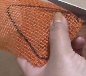 Cutting out the carrot shape in orange burlap