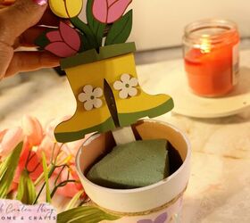 diy maceta de terracota flor de primavera, Mano sujetando decoraci n primaveral sobre maceta