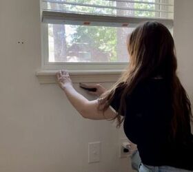 mejora tus ventanas aadiendo nuevos marcos y molduras, Una mujer rompe la masilla para quitar el alf izar de la ventana