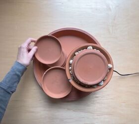 Stacking terracotta saucers and pots to create the fountain tiers