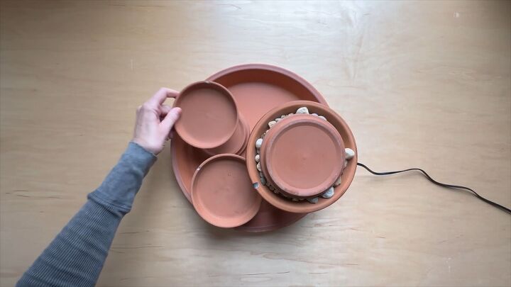 Stacking terracotta saucers and pots to create the fountain tiers