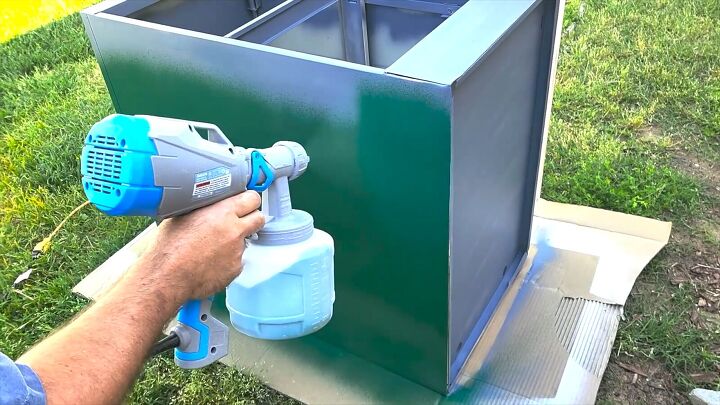 Using a paint sprayer on the cabinet