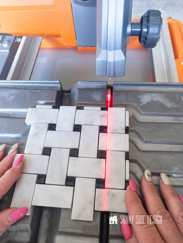Black and white basketweave tile is cut with a tile saw to fit the niche