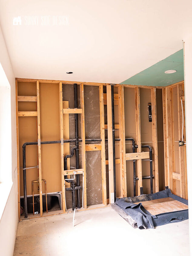 Framed wall with water lines and sewer plumbing pipes