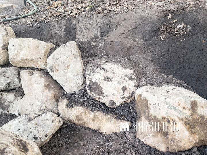 Second row of rocks are placed and fill dirt is added to stabilize this row of the retaining wall