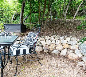 Gathering area in the backyard with a rock retaining wall and a dining table and chairs