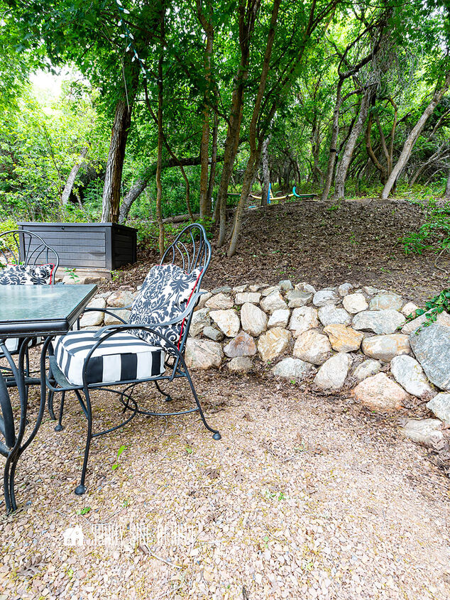 Gathering area in the backyard with a rock retaining wall and a dining table and chairs