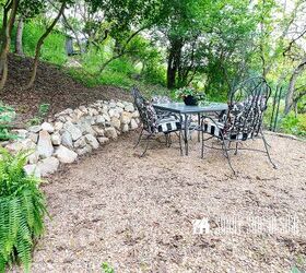 Gathering area with a dining table in a backyard with a slope and a small retaining wall