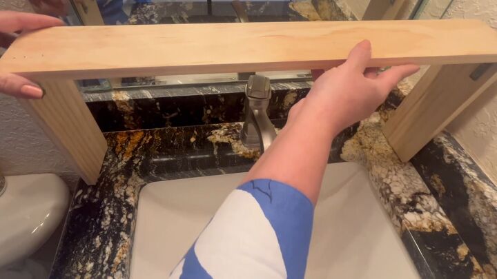Placing the assembled shelf on the sink