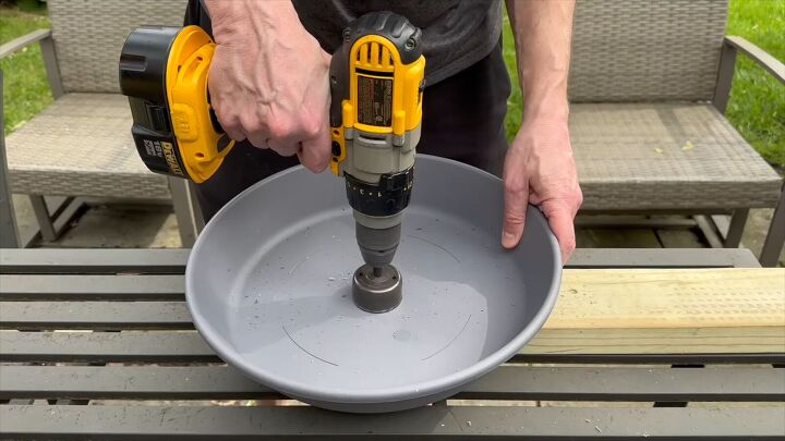 Drill 2-inch holes in the center of the planter and saucer to fit the outdoor umbrella