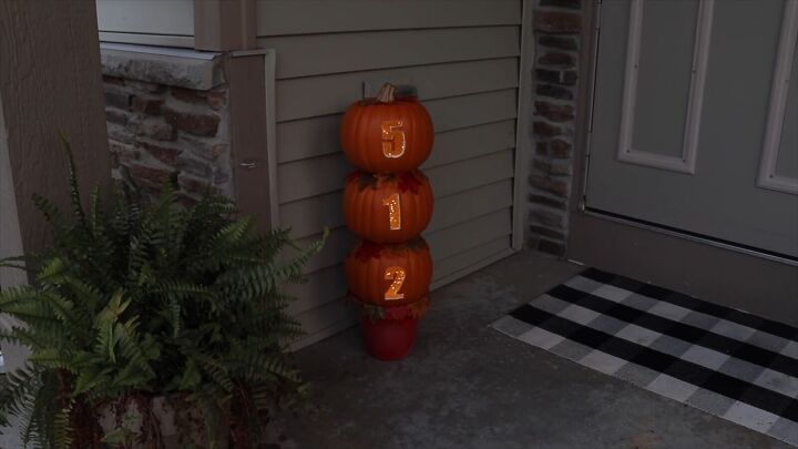 A stack of carved pumpkins with fairy lights placed inside