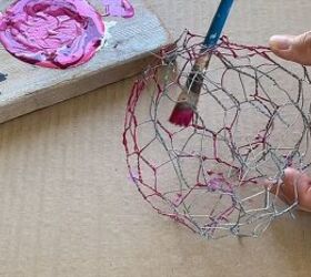 Using a paintbrush to coat the inside of the ball with paint drips