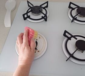 Sponge and frozen dishwashing cube scrubbing a greasy stovetop