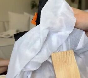 She glues a small piece of wood to a piece of fabric for this cute porch decor idea for Halloween