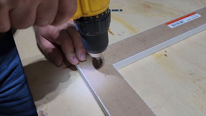 Pre-drill and attach flat corner braces to secure the TV frame’s structure.