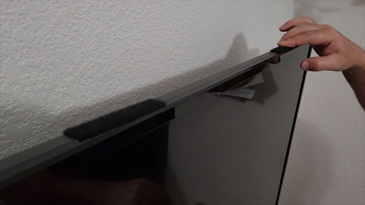 Use Velcro strips to securely attach your picture frame around TV for a polished look