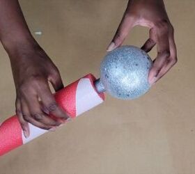 Securing the light-up ornament to the top of your North Pole DIY project