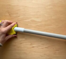 She cuts a slit in the top of a sponge and sticks it on a broom handle for this brilliant trick