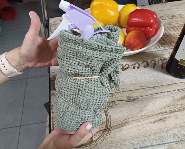 Spray bottle with the mixture, wrapped in a towel and secured with an elastic band