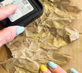 Woman drags brown ink onto the crumpled paper leaf