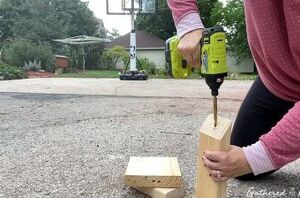 She drills a hole through some scrap wood for cute fall decor that works even after Halloween