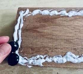 She glues beads on a piece of scrapwood for charming and welcoming decor