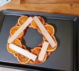 Stick popsicle sticks on sliced oranges to add more Christmas vibes to your home