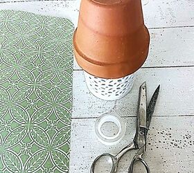 She sticks a terracotta pot over a candle holder for this $5 Christmas decor idea