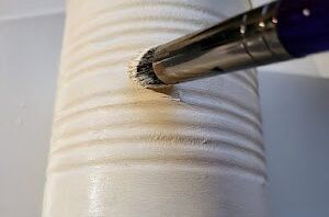 She paints an empty tin can white for the prettiest reason