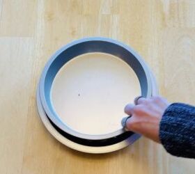 She stacks a dollar store pie pan over a cake pan for incredibly useful storage