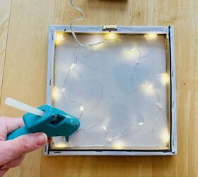She glues fairy lights behind Dollar Tree art for really cool Valentine's Day decor