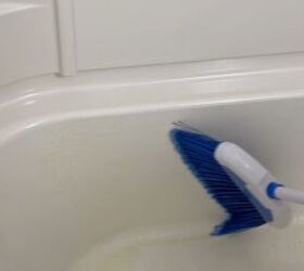 deep clean your shower floor, Scrubbing with a broom in the shower