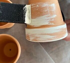 She brushes mini terracotta pots with paint for the cutest reason...