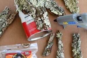 She glues pieces of tree bark to a tin can for this beautiful springtime idea