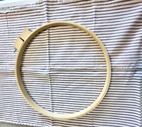 She places an embroidery hoop over some fabric to solve this very messy household problem