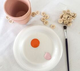 She sticks buttons on a mini clay pot for this simple spring table accent