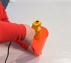 Attaching broom handle inside cone for DIY carrot decoration