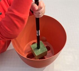 Broom handle inserted into floral foam inside planter