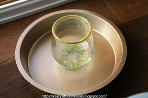 She places a candle holder in a baking pan for exquisite decor