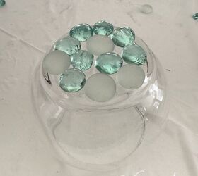 She glues glass gems on the outside of a bowl for an outdoor decor hack we actually can't wait to copy
