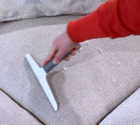 Removing stubborn pet hair from couch fabric using a rubber squeegee hack