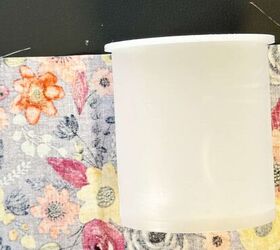 She placed an empty cake frosting container on a piece of fabric for adorable decor