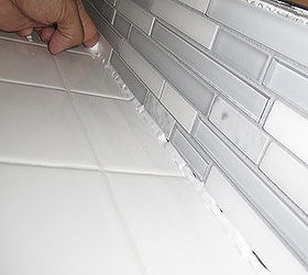 how to update a backsplash, kitchen backsplashes, kitchen design, Squeeze a thin bead of tub and tile caulk between the back splash and countertop