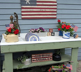 my potting bench has gone red white blue, flowers, gardening, outdoor living, A folk art flag sign USA Blocks and a God Bless America sign along with some miniature flags set a patriotic theme