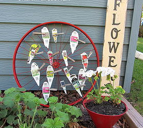 bike wheel plant label tag organizer, flowers, gardening, repurposing upcycling, The plant labels are alphabetized by letter and then attached with weathered clothespins to the wheel spokes