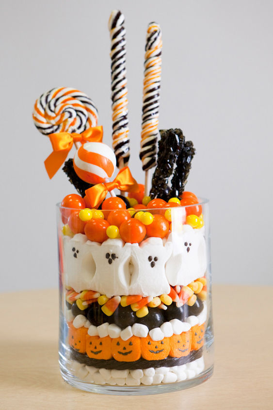 5 frightfully fast halloween decorations, halloween decorations, seasonal holiday d cor, Is something missing from your dinner table say perhaps a perfect and effortless Halloween centerpiece Dump the candy corn into the jar or vase then add fall flowers or lollipops to the candy to secure them in place